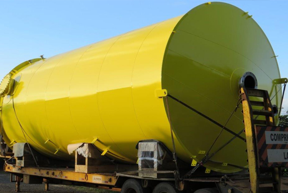 Tanque horizontal pintado de amarelo sobre carreta